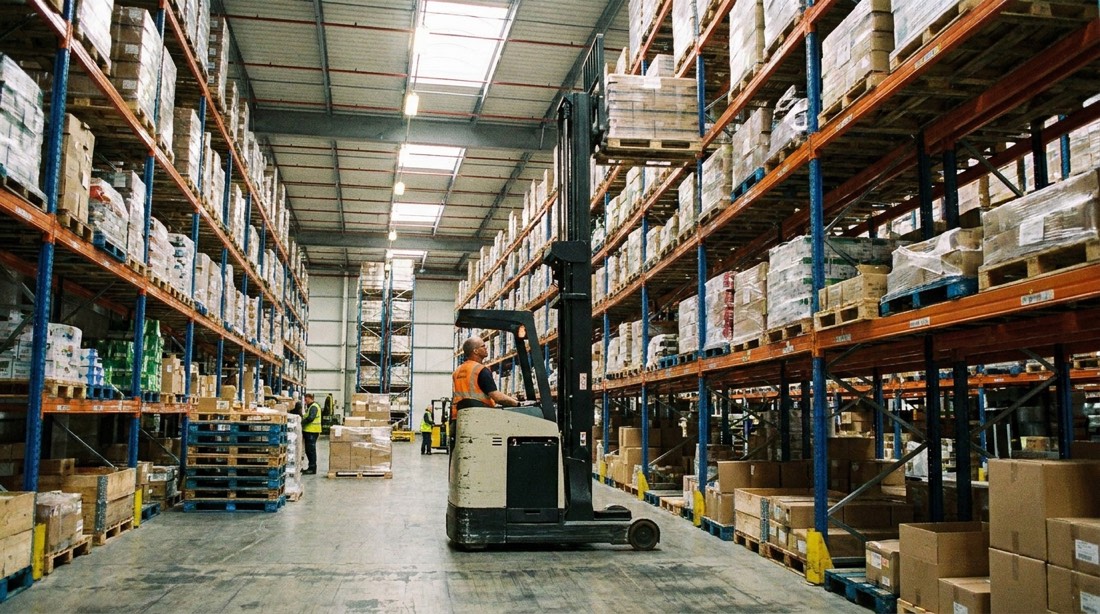 Autoelevador alcanzando pallets en racks altos